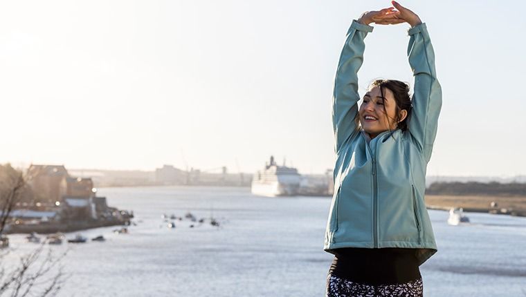 Women outdoors stretching.