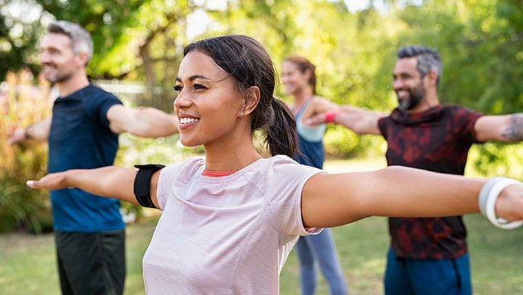 A group of people stretching outside focused on their hormone health.