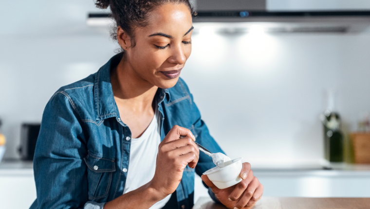 Woman eats yogurt.