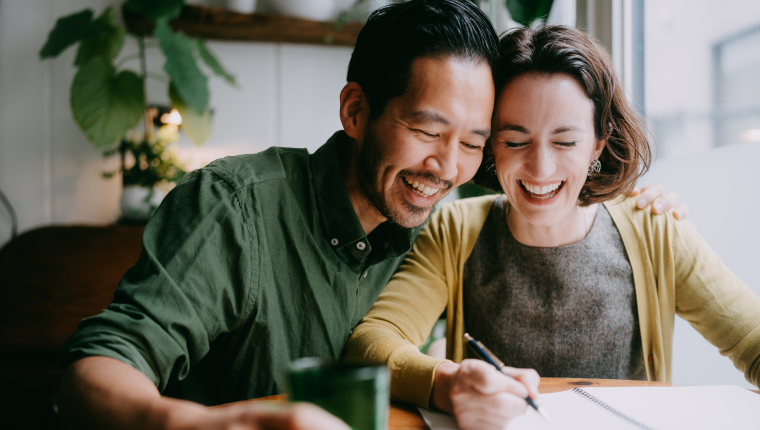 Man and woman work together at table.