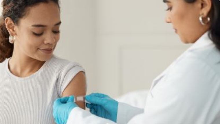 Nurse applies band aid after giving vaccine.