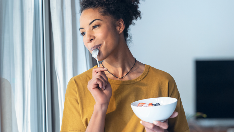 Woman eats cereal.